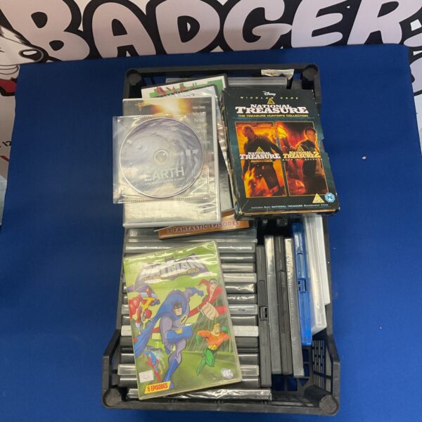 Mixed DVD lot in a crate, assorted movie collection.