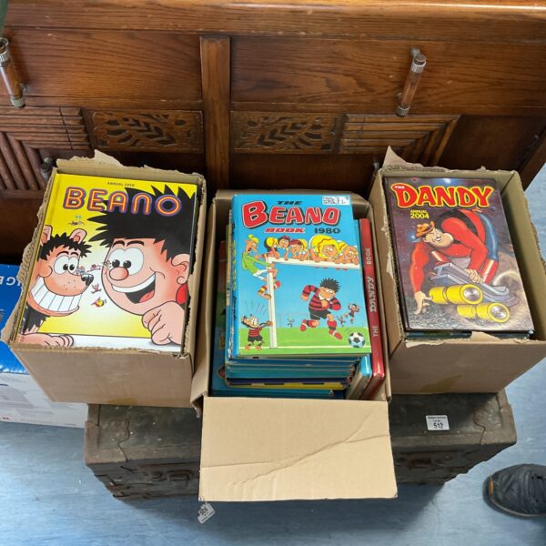 Stack of vintage Beano and Dandy annuals in cardboard boxes.
