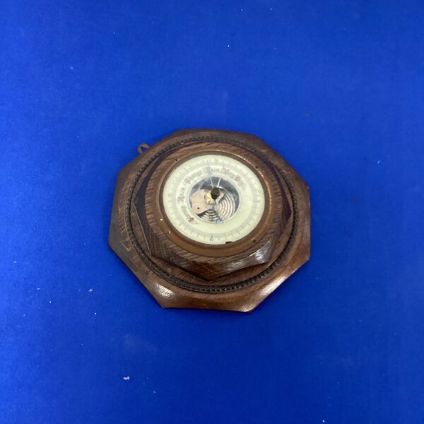 Vintage wall barometer with carved wooden surround.