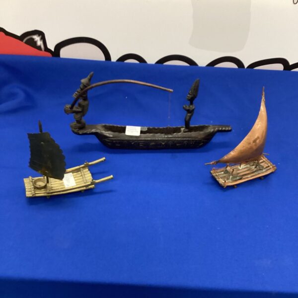 Lot of three handcrafted wooden sailing boats for nautical decor.