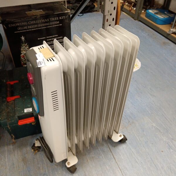 White vintage oil filled radiator with castors.