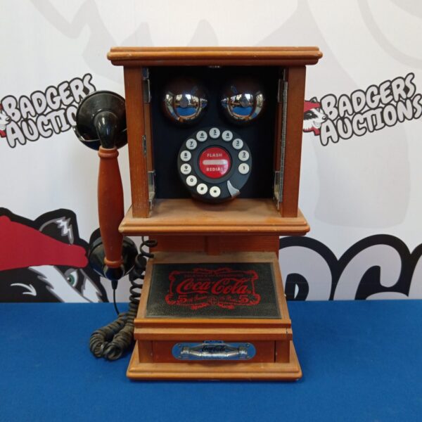 Red vintage Coca-Cola wall mounted rotary dial telephone.
