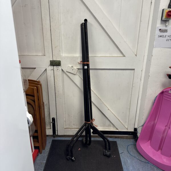 Black metal clothes rail on casters for garment storage.