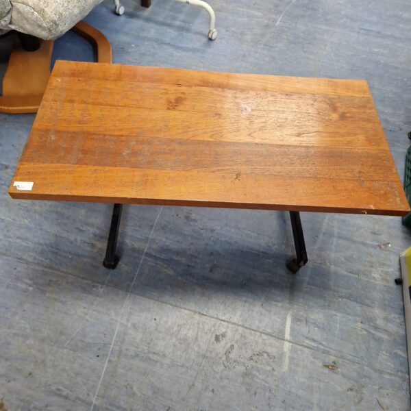 Vintage coffee table with wooden top and metal frame.