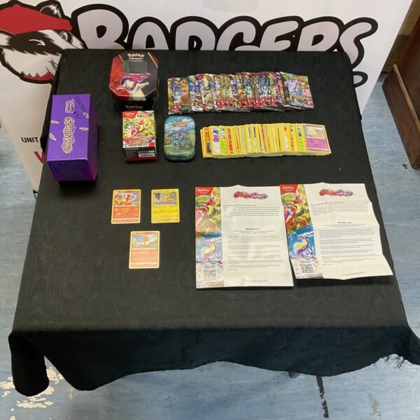 Pokemon card collection lot with tins and booster packs.