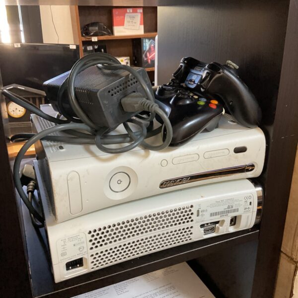 Two black Microsoft Xbox 360 E gaming consoles.
