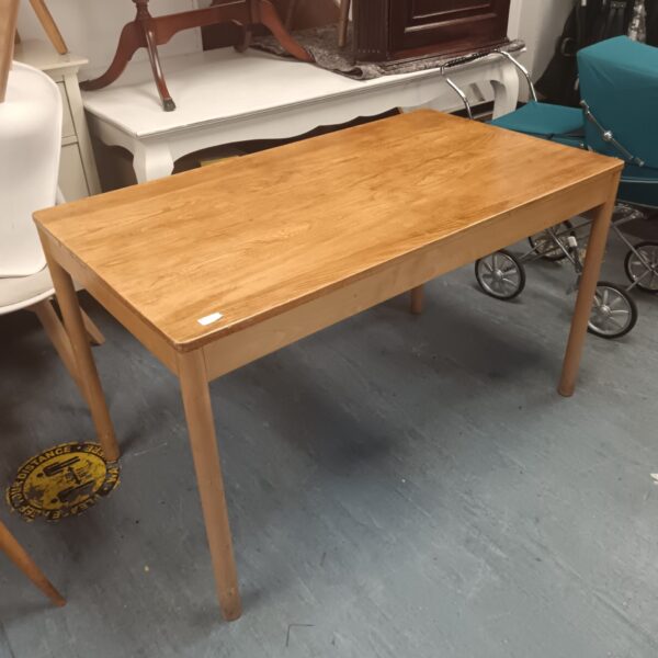 Vintage Ercol dining table with blonde wood finish.