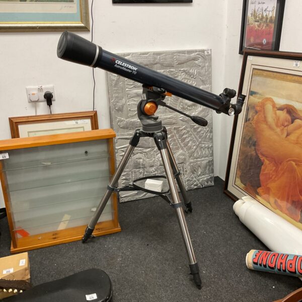 Celestron AstroMaster 70 telescope on tripod, vintage astronomical instrument.