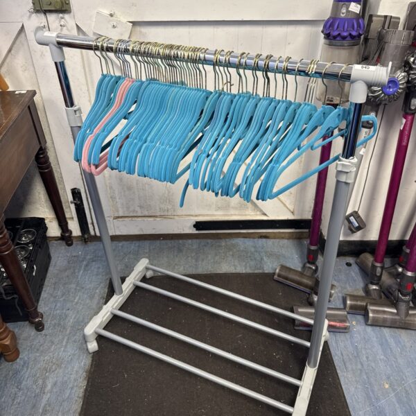 Extendable clothes rail with suede hangers for laundry storage.