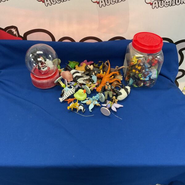 Collection of plastic farm animals and a Santa Claus globe.