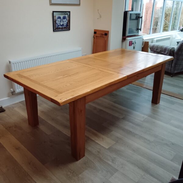 Large solid oak dining table in a home setting.