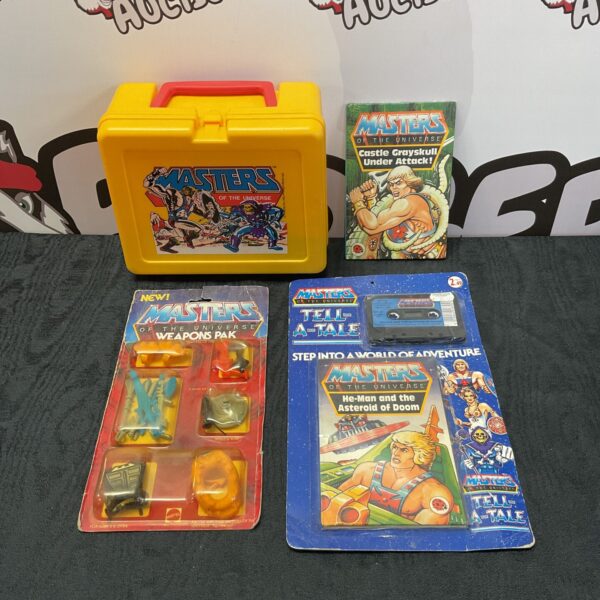 Vintage Masters of the Universe lunchbox and weapons pack collectible toy lot.