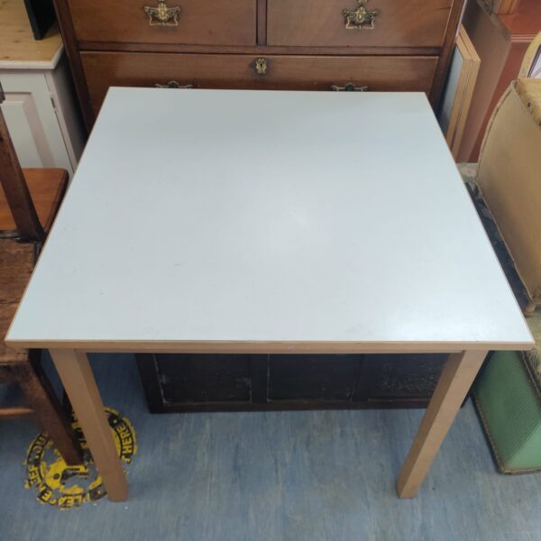 Painted wooden extending dining table in a kitchen setting.