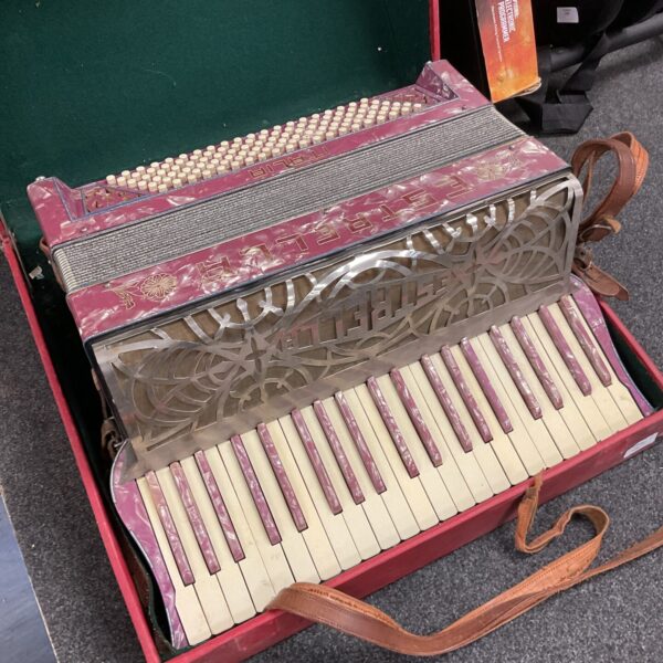 Front view of a vintage Estrella accordion with keys and buttons.
