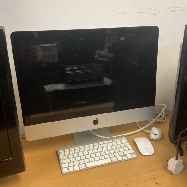 Front view of a vintage Apple iMac A1311 computer with keyboard and mouse.