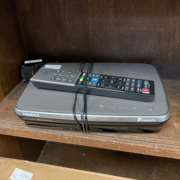 Black Humax TV box with remote control on a shelf.