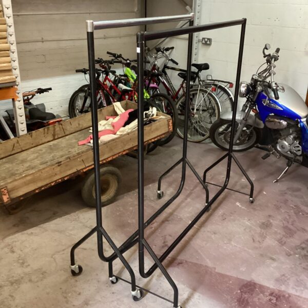 Metal rolling garment rack for clothing storage and display.