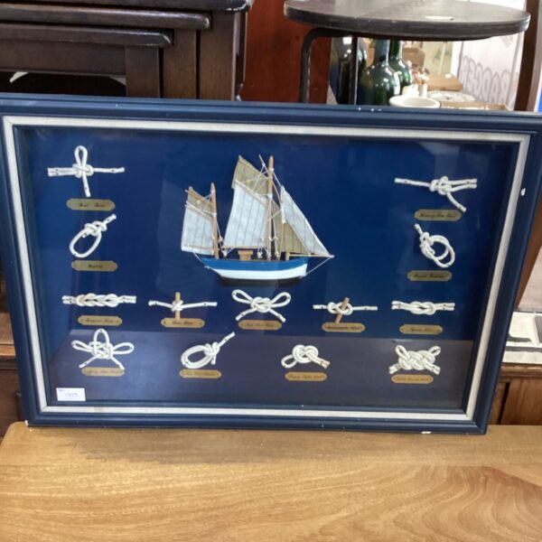 Vintage nautical diorama displaying intricate ships knots under glass.