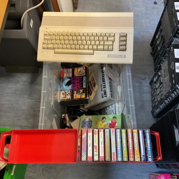Vintage Commodore 64 computer with game cartridges and cables.