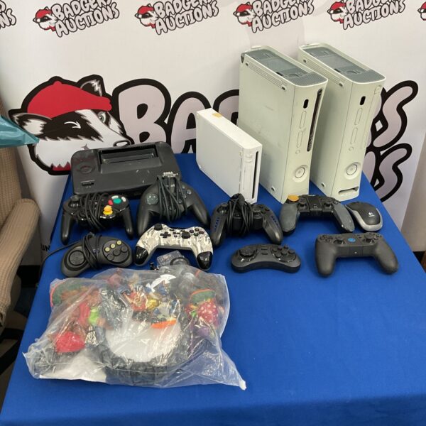 Mixed lot of retro gaming consoles and controllers.