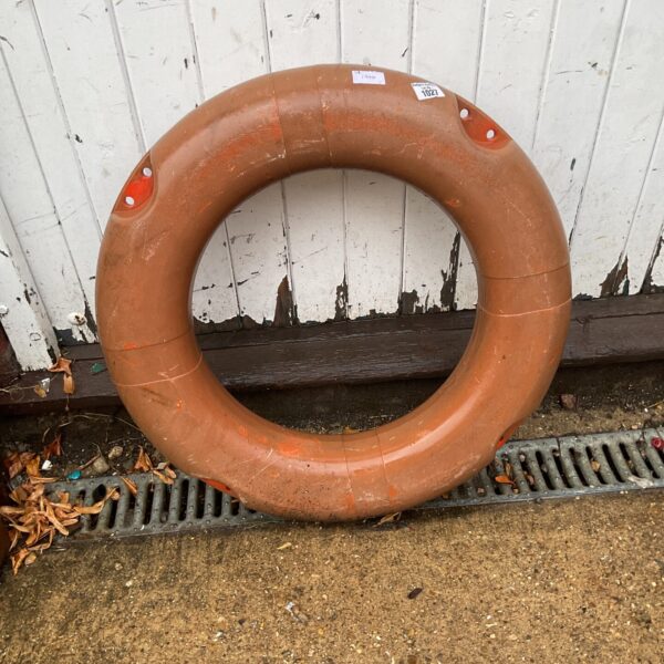 Bright orange life preserver rescue ring for marine safety.