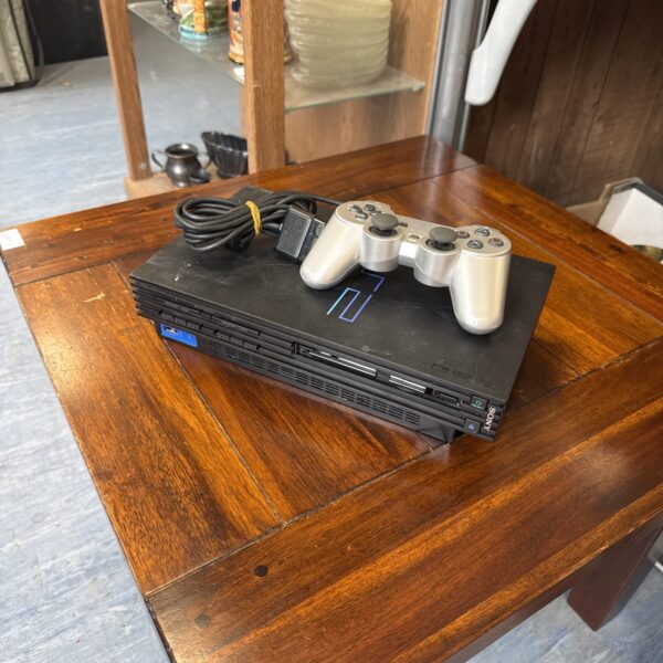Front view of a Sony PlayStation 2 console with controller.