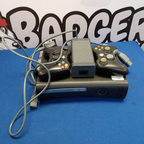 Black Xbox 360 E console with two controllers for retro gaming.