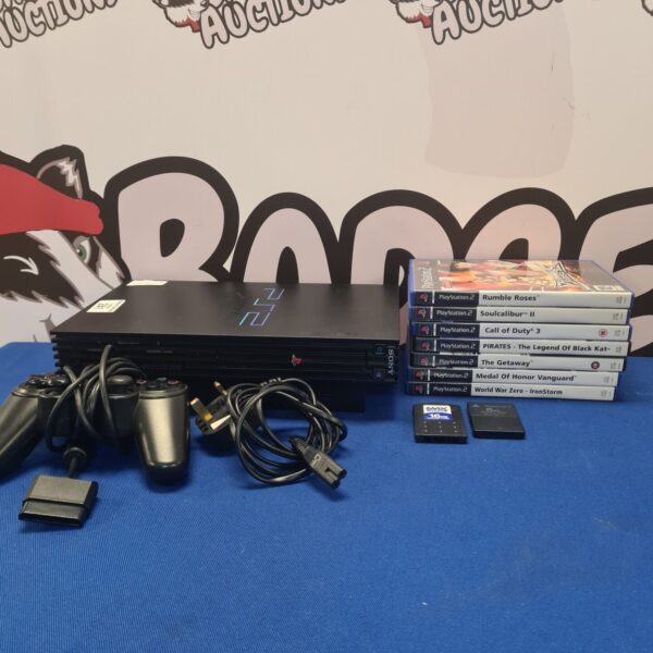 Silver Sony PlayStation 2 console with games and controller