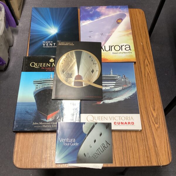 Collection of cruise ship books and brochures, including Cunard vessels.