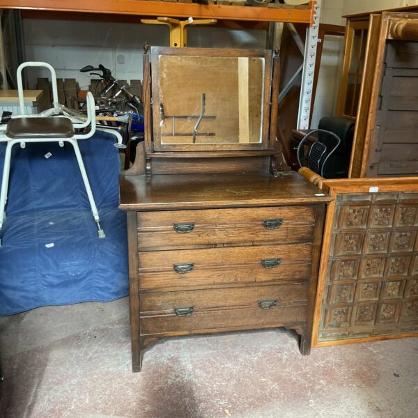 Front view of a vintage oak dressing table with drawers.