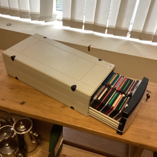 Vintage floppy disk holder with 3.5 inch disks inside.