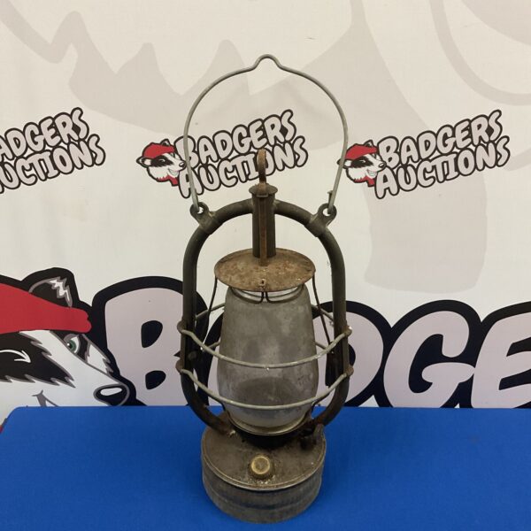 Vintage paraffin storm lantern with brass cage and glass chimney.