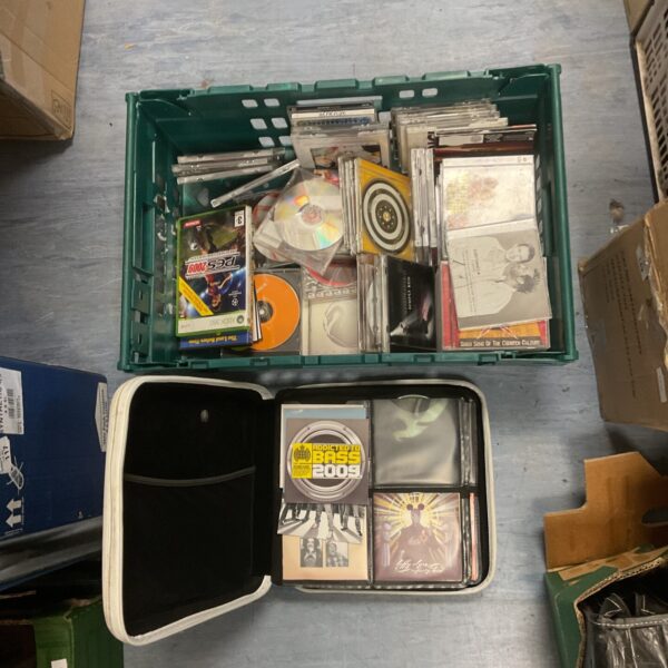 Mixed lot of CDs and PES 2009 game in a green crate.
