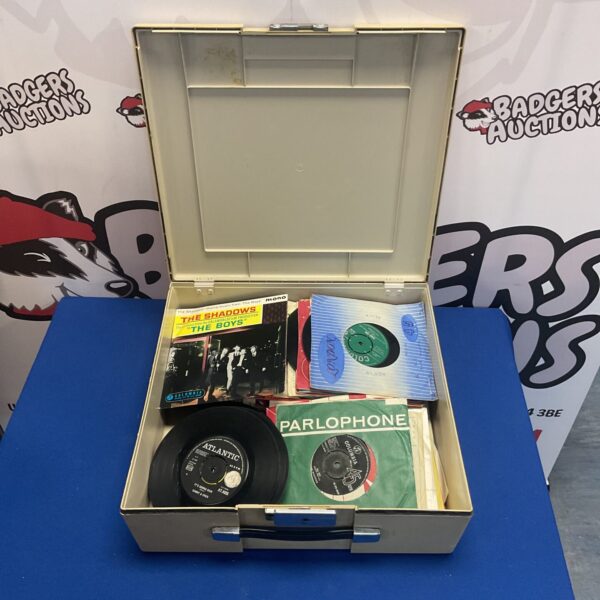 Vintage carrying case filled with 7-inch vinyl singles, including Beatles records.