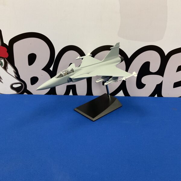 Detailed Gripen model aircraft on blue background.