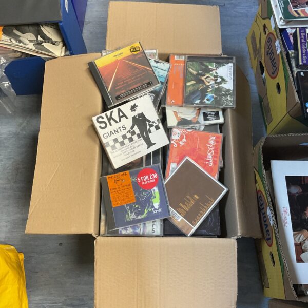 Large box filled with a mixed collection of compact discs.