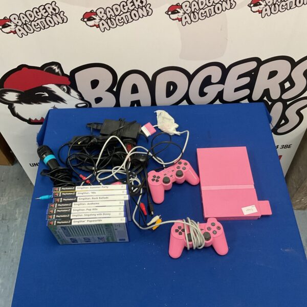 Pink Playstation 2 console with SingStar games and controllers.