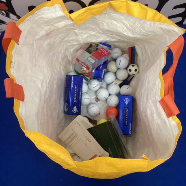 Mixed lot of used golf balls, tees, and a scorecard for golfers.