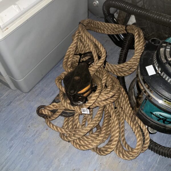 Thick rope and metal pulleys for a vintage lifting system.