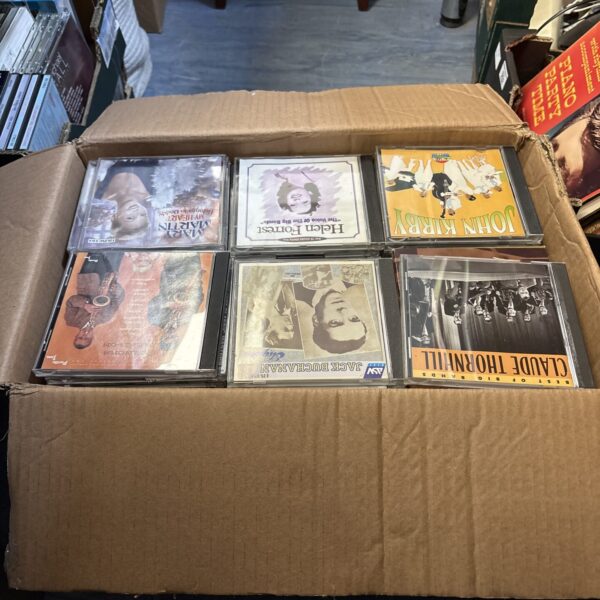 Box full of assorted mixed CDs for music collection.