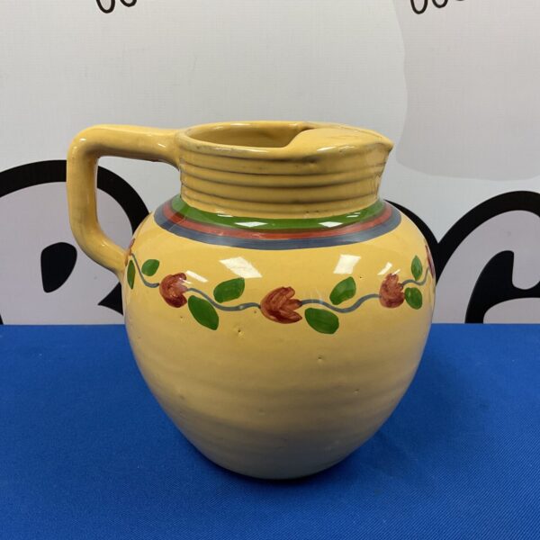 Yellow Provence jug with floral vine pattern.