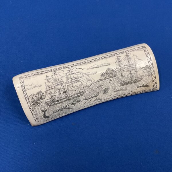 Antique scrimshaw carving of whaling scene near Tahiti, detailed whalebone art.