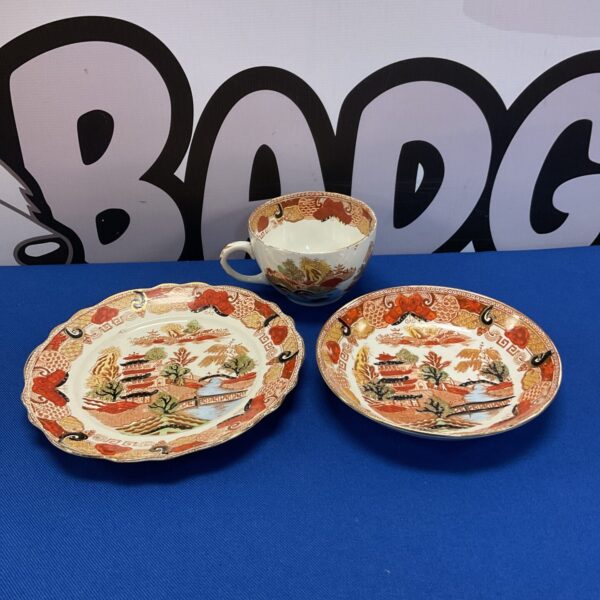 Antique Chinese pagoda tea set with teacup, saucer, and plate.