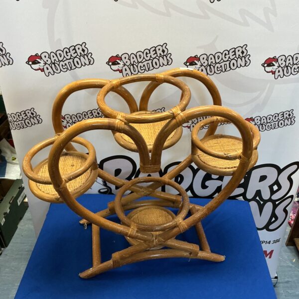 Three-tiered bamboo plant stand for displaying indoor plants.