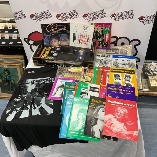 Vintage Beatles fan club collection with magazines, posters, and a T-shirt.