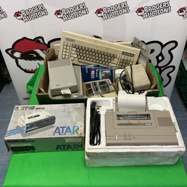 Vintage Commodore and Atari computer hardware lot with disk drives and keyboards.