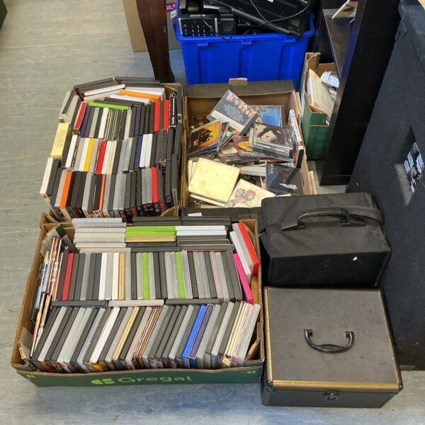 Large lot of DVDs and CDs with aluminium case for storage.