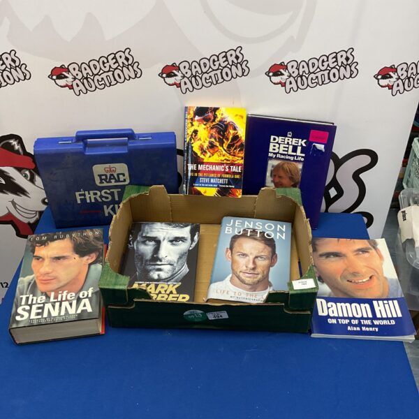Selection of motor racing books and a vintage RAC first aid kit.