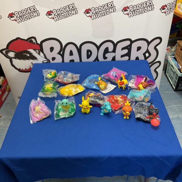 Collection of Pokemon Happy Meal toys on a blue surface.