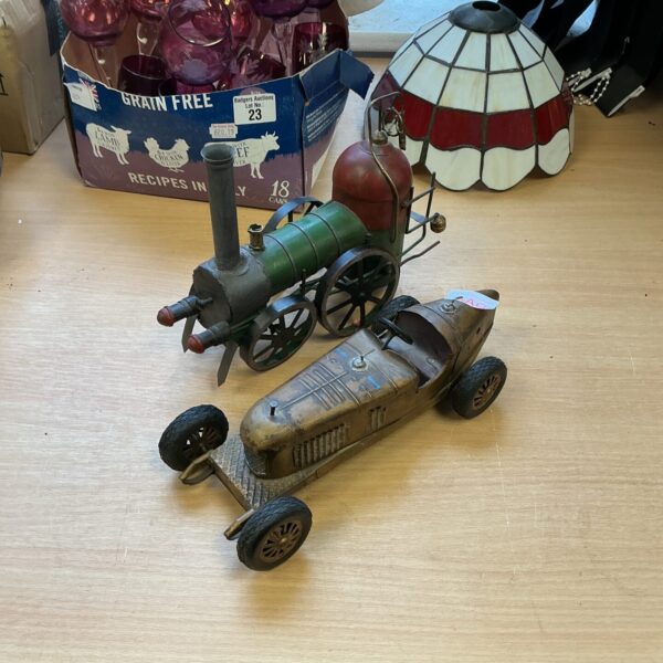 Vintage tin plate locomotive and race car toy vehicles.